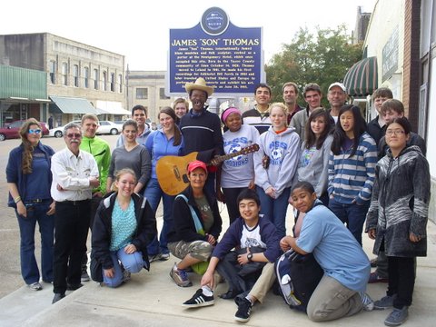 Photo:  Students from the Colorado Springs School in front of the Highway 61 Blues Museum in downtown Leland.  The Mississippi Blues Trail marker celebrates the life of Bluesman James "Son" Thomas.  Pat Thomas, James's son, is holding his guitar in front of the marker.  