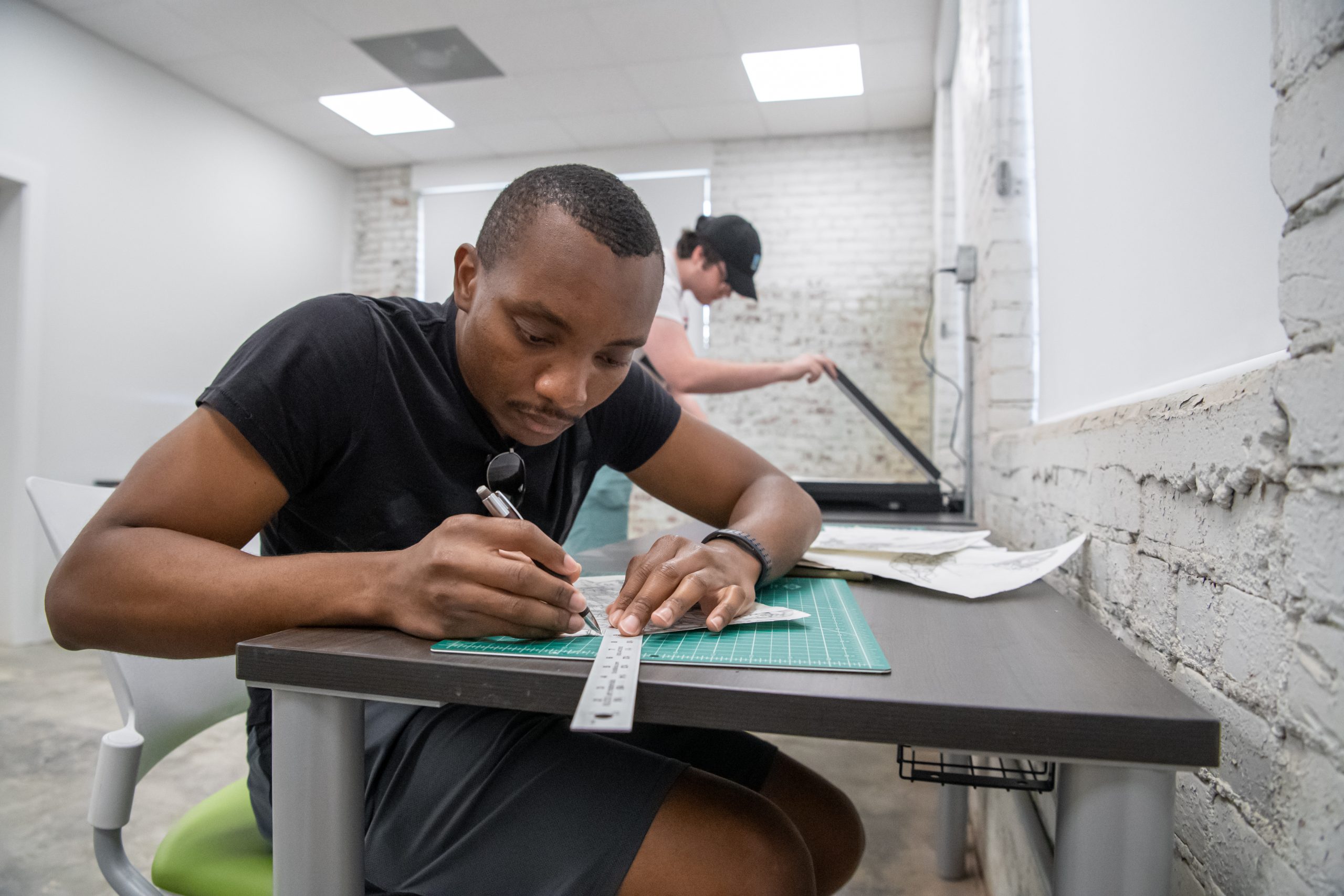 Student sitting at a table, drawing in the art lab.