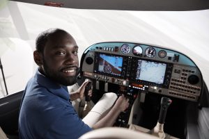 Student in flight simulator with hands on controls
