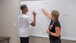 Student and professor at a whiteboard, filling in a positioning map.