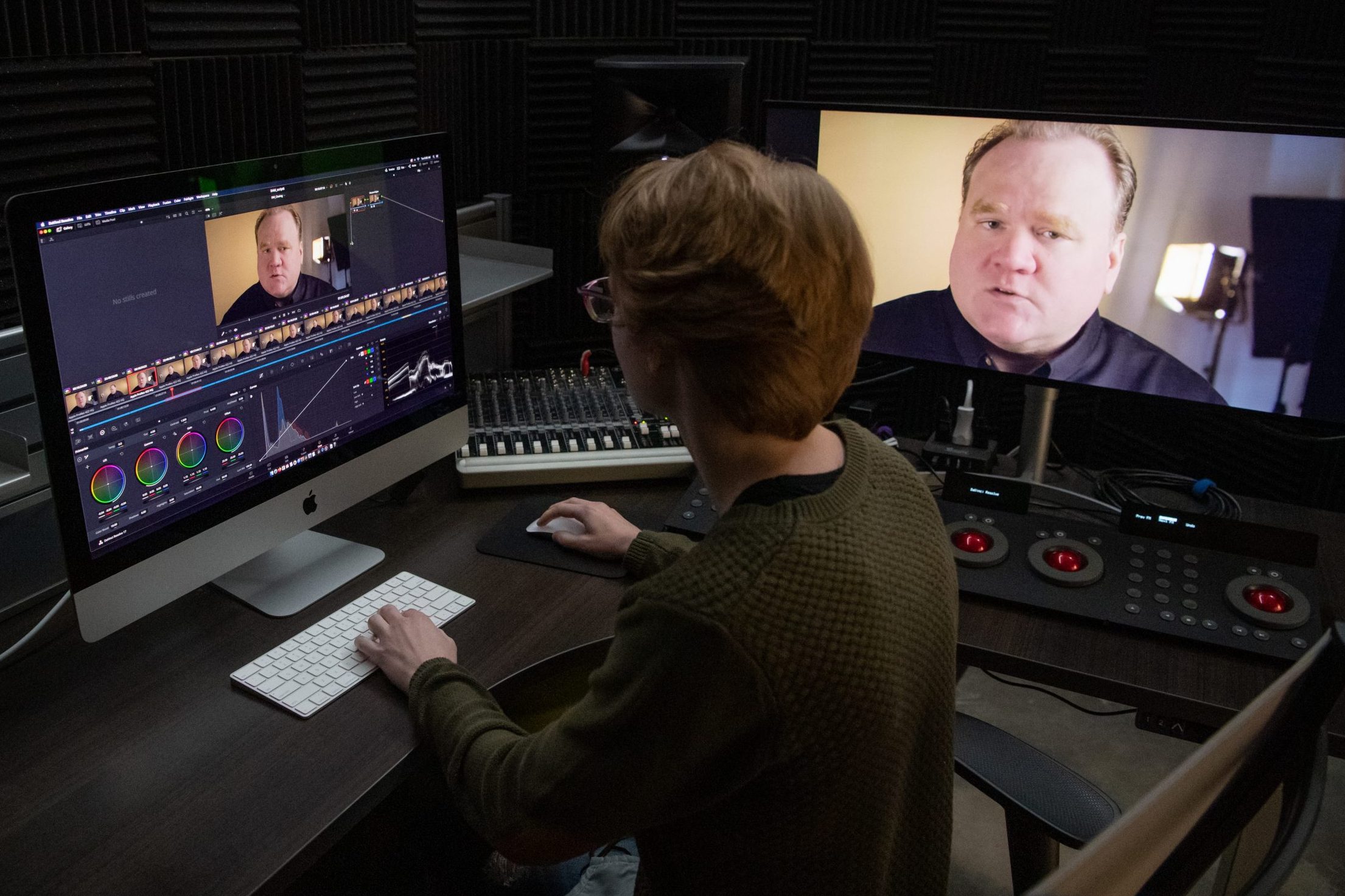 Student sitting at a desk editing video