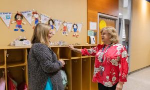 Two school administrators having a conversation in an elementary school hallway.