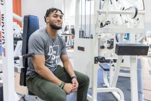 A man sitting on an exercise machine in a fitness center.