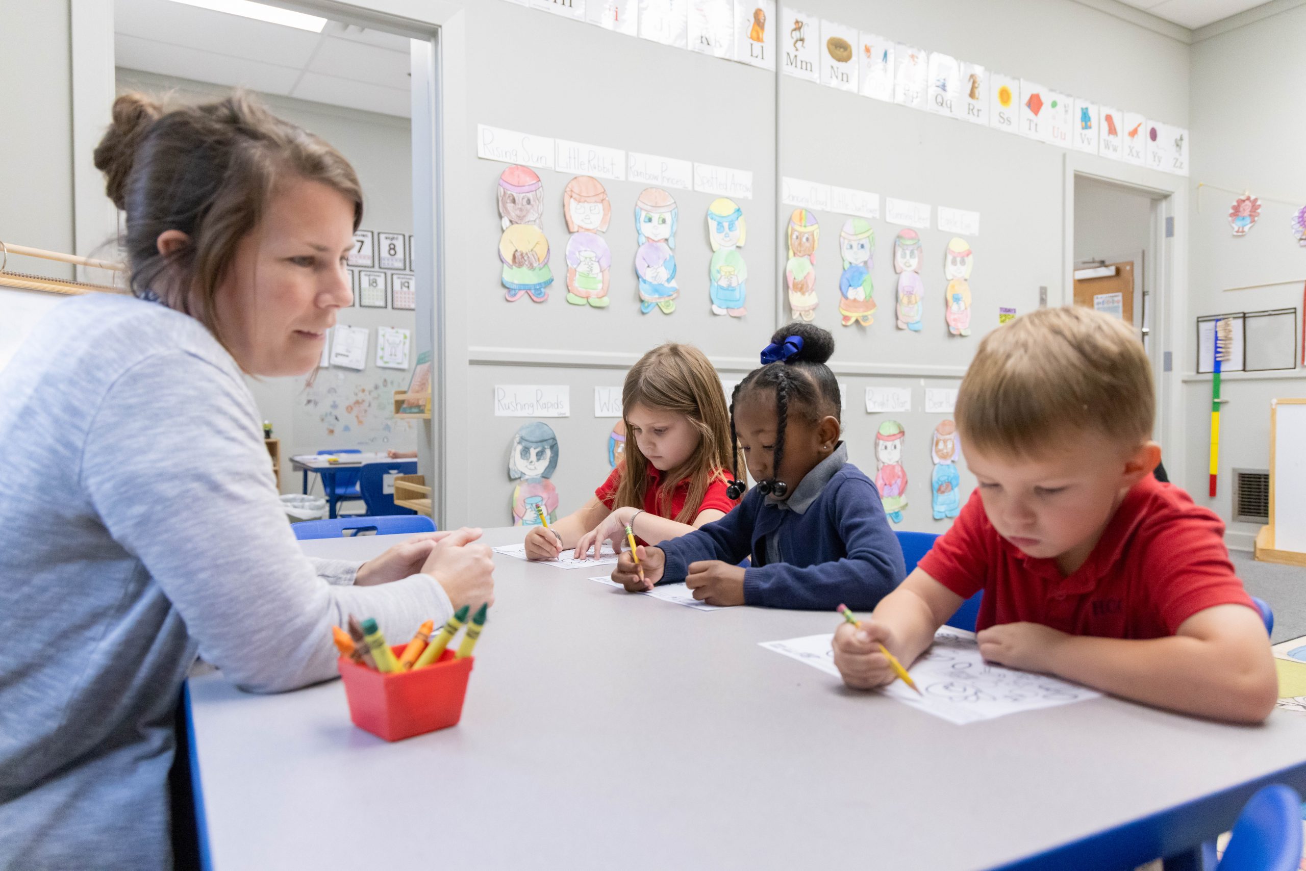 Teacher working with young children in a classroom.