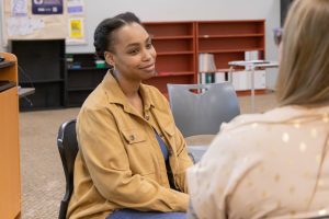 Student engaged in a one-on-one discussion during a classroom activity.