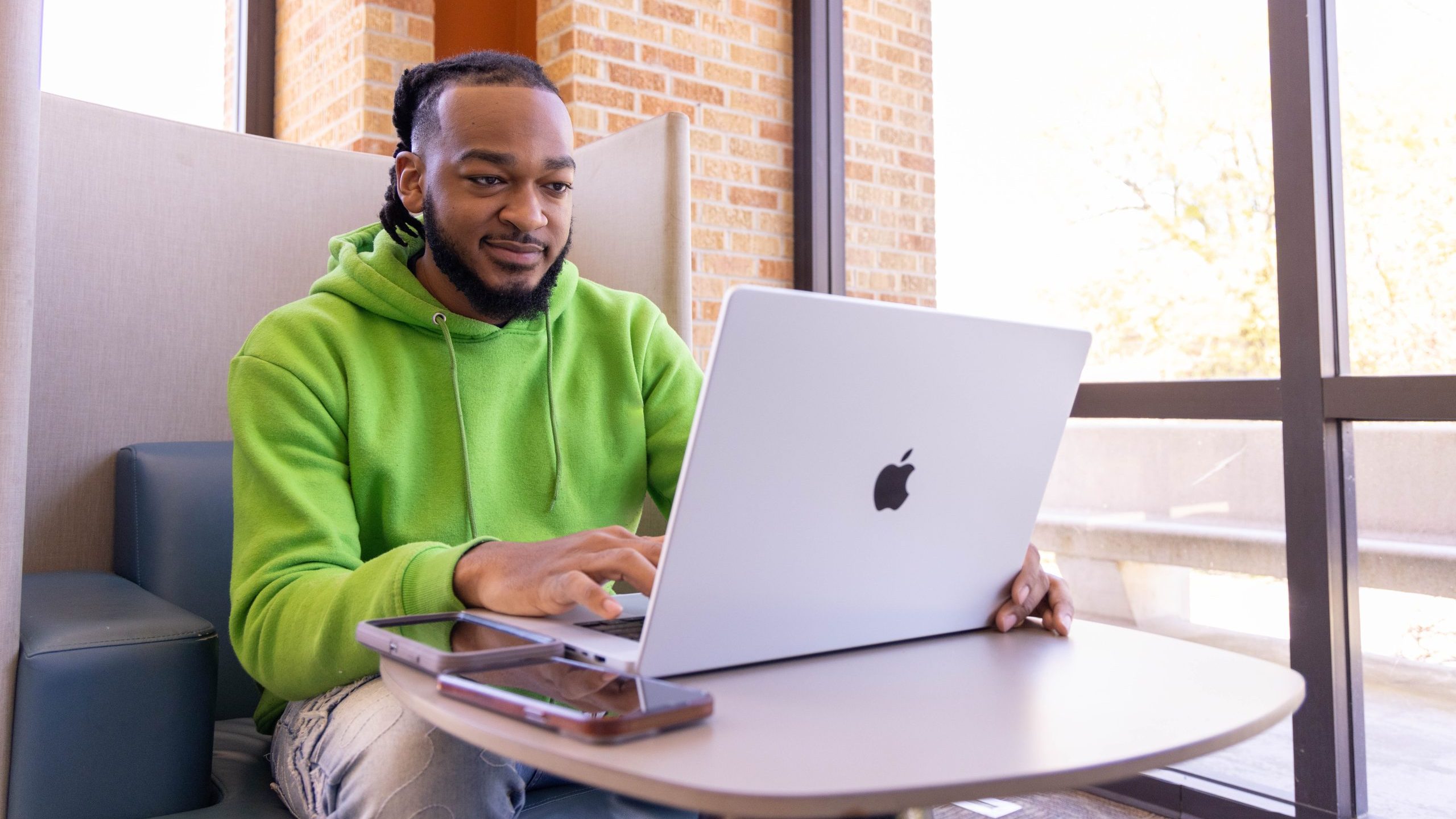 Student working on a laptop in a campus study space.