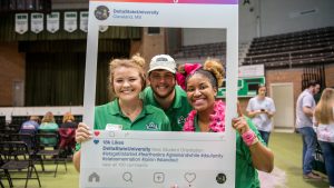 Students smiling at camera with Delta State Instagram frame.