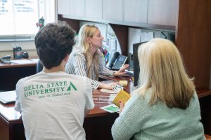 Student with parent talking to financial aid counselor.