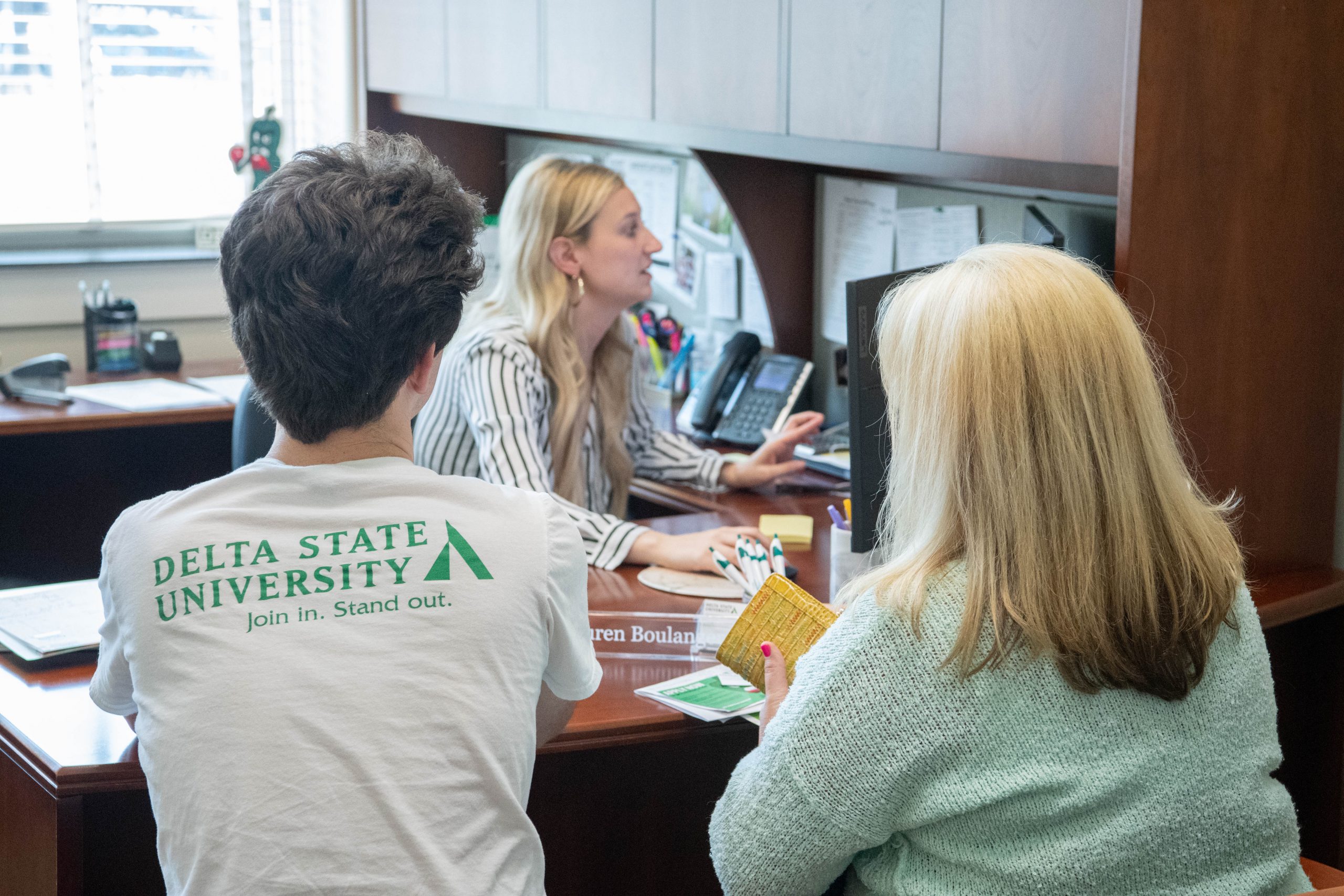 Student with parent talking to financial aid counselor.