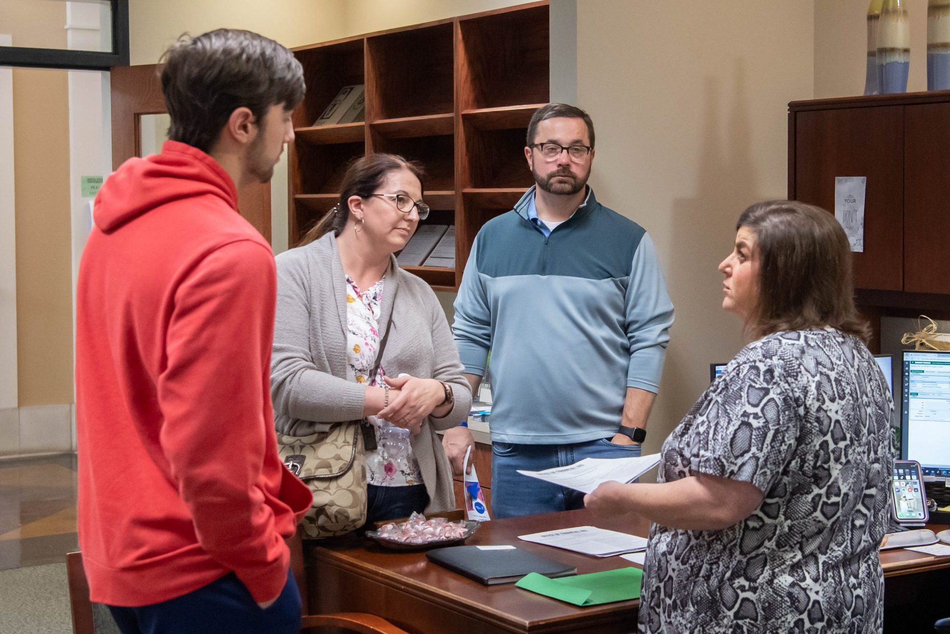 Student and parents speaking with financial aid representative.