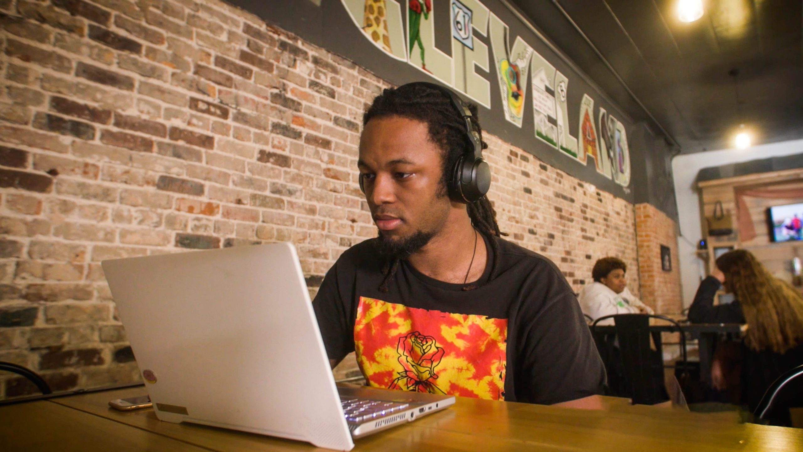 Student at coffee shop doing homework on laptop.