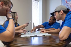 A group of aviation students sitting around a table discussing flight materials.