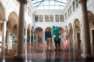 Students and Delta State Mascot, smiling while walking through administrative building.
