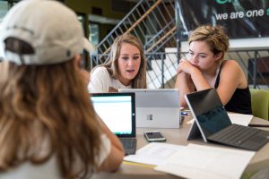 Students in the student union reviewing student business services forms and instructions.