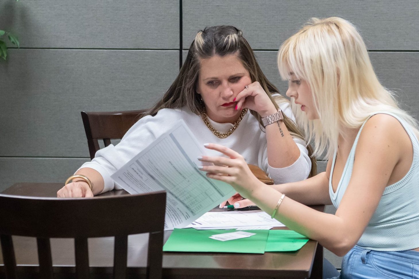 Student with parent in office setting, reviewing financial aid information together.