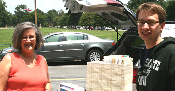 Georgia Murphy presents teaching materials accumulated throughout her career to Greg Claus, director of workshops and resources for the Teach For America Delta Institute.