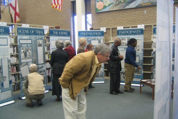 Man bows down to get a closer look at an exhibit