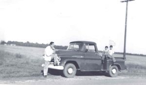 Men posing with pick-up truck, B&W.