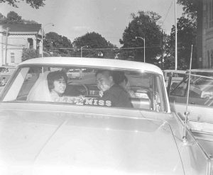 Just married photograph, bride and groom in backseat, B&W.