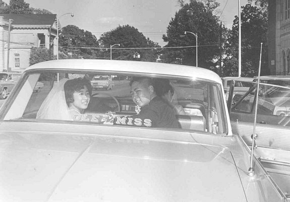 Just married photograph, bride and groom in backseat, B&W.