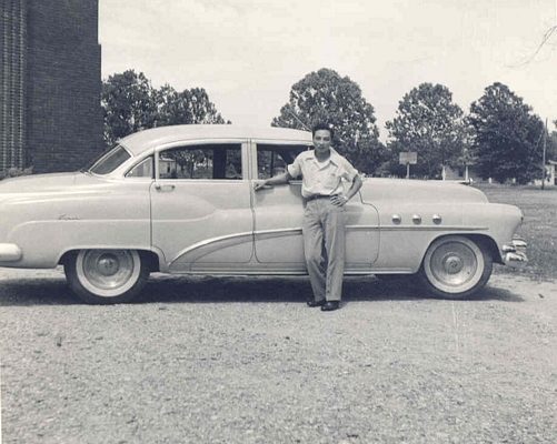 Man posing in front of car, B&W.