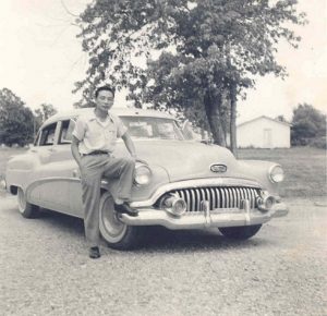 Man posing with car.