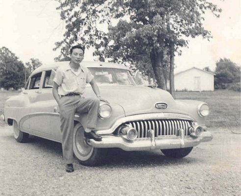 Man posing with car.