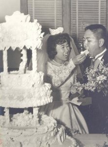 Bride feeds wedding cake to groom, B&W.