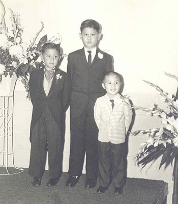 Portrait of three young boys attending a wedding. B&W.