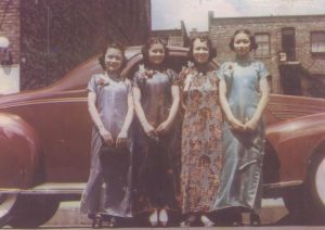 Four women posing next to car, Color.