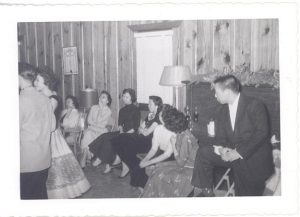 Young adults sitting next to each other at social event, B&W.