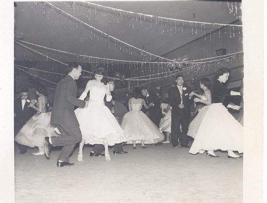 Young adults dancing at social event, B&W.