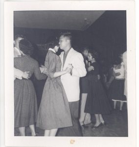 Young man and woman dancing together at social, B&W.