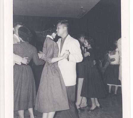 Young man and woman dancing together at social, B&W.