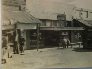 B&W, storefront with parked horse.