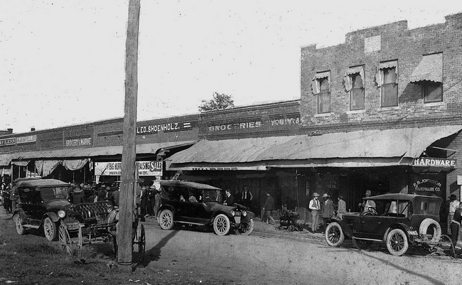 Black and White, storefront, with 1920 Fords out front.