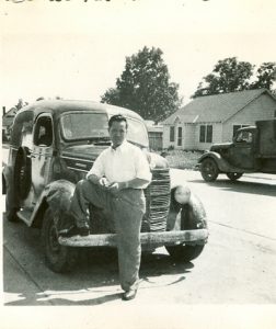 Man poses with pick-up. B&W.