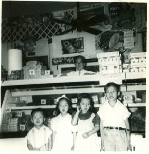 4 children, black and white, pose in fornt of counter.