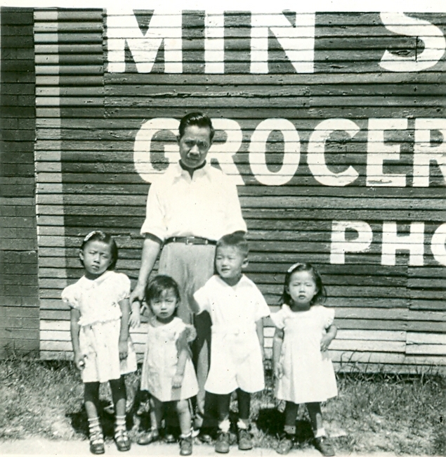 Man poses with 4 children, B&W.