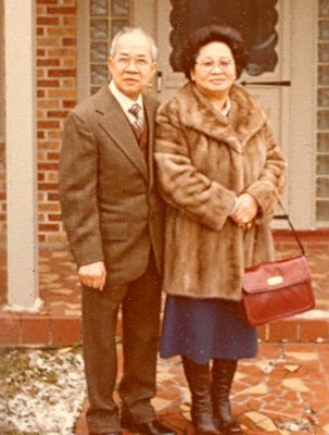 Portrait of couple in front of house, color.