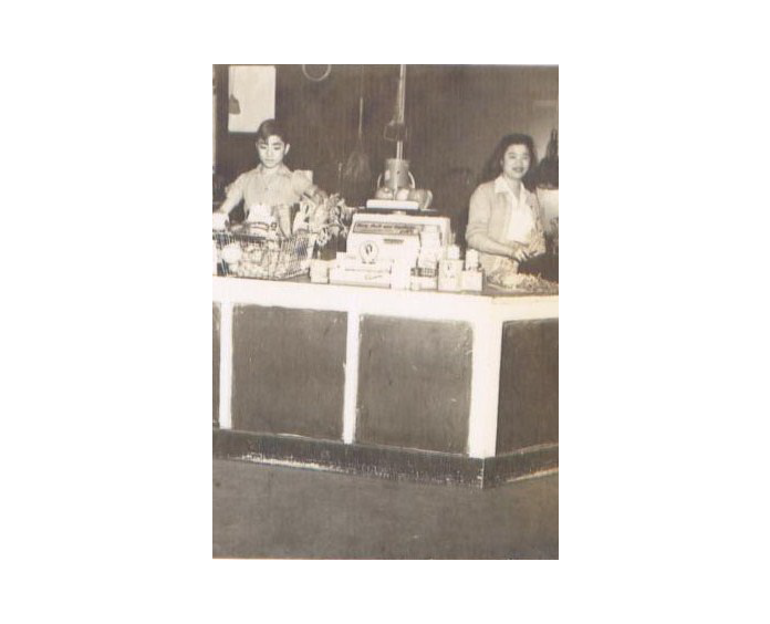 Two women stand behind a counter.