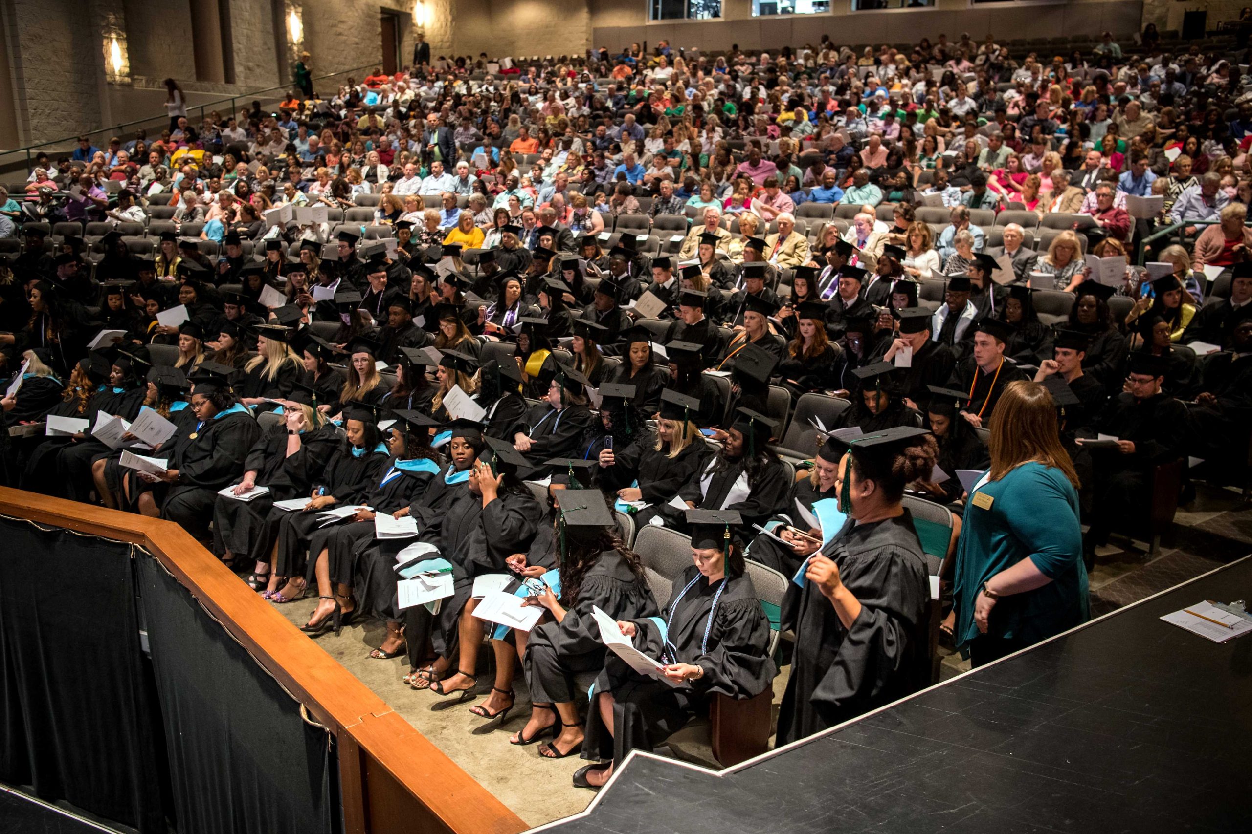 A full theater of people at the Bologna Performing Arts Center for a commencement ceremony.