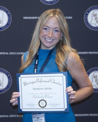 a blonde woman in a blue dress holding an award certificate