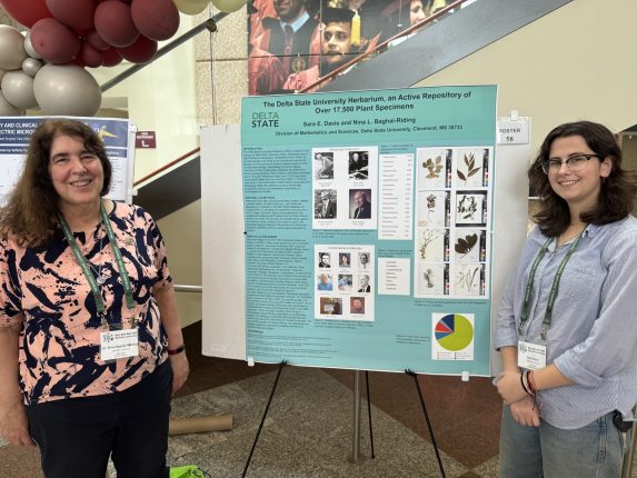 two women standing on either side of a poster