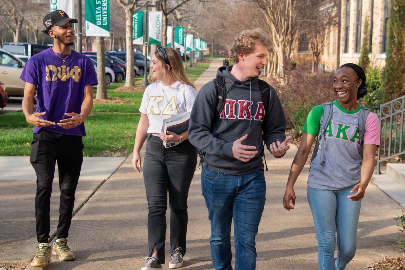 Greek Life students walking and engaging with each other on campus.