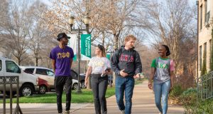 Greek Life students walking and engaging with each other on campus.